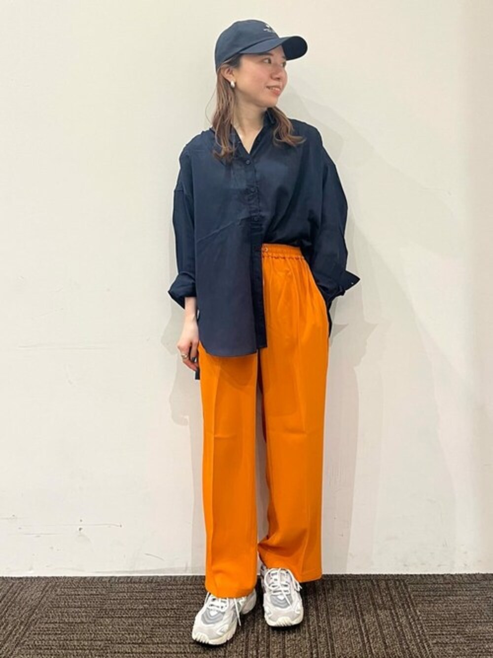 ブルー系のシャツ/ブラウス、オレンジ系のその他パンツ、ブルー系のキャップを着用したレディースの春コーディネートの1枚目の写真