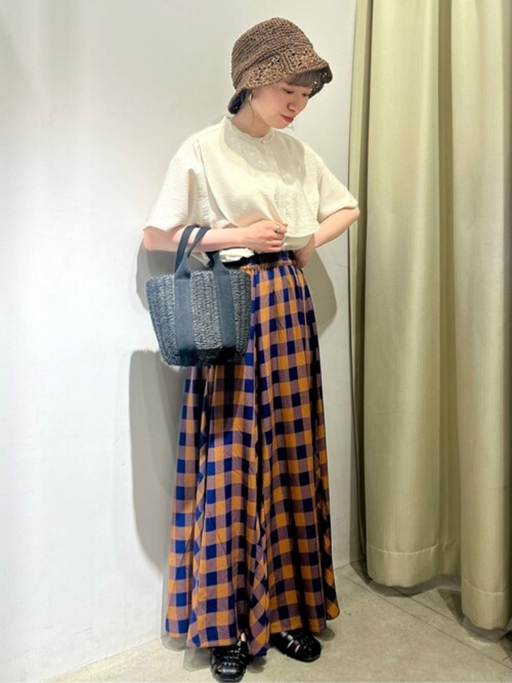 ホワイト系のシャツ/ブラウス、ブルー系のスカート、ブラック系のハンドバッグを着用したレディースの春コーディネートの1枚目の写真