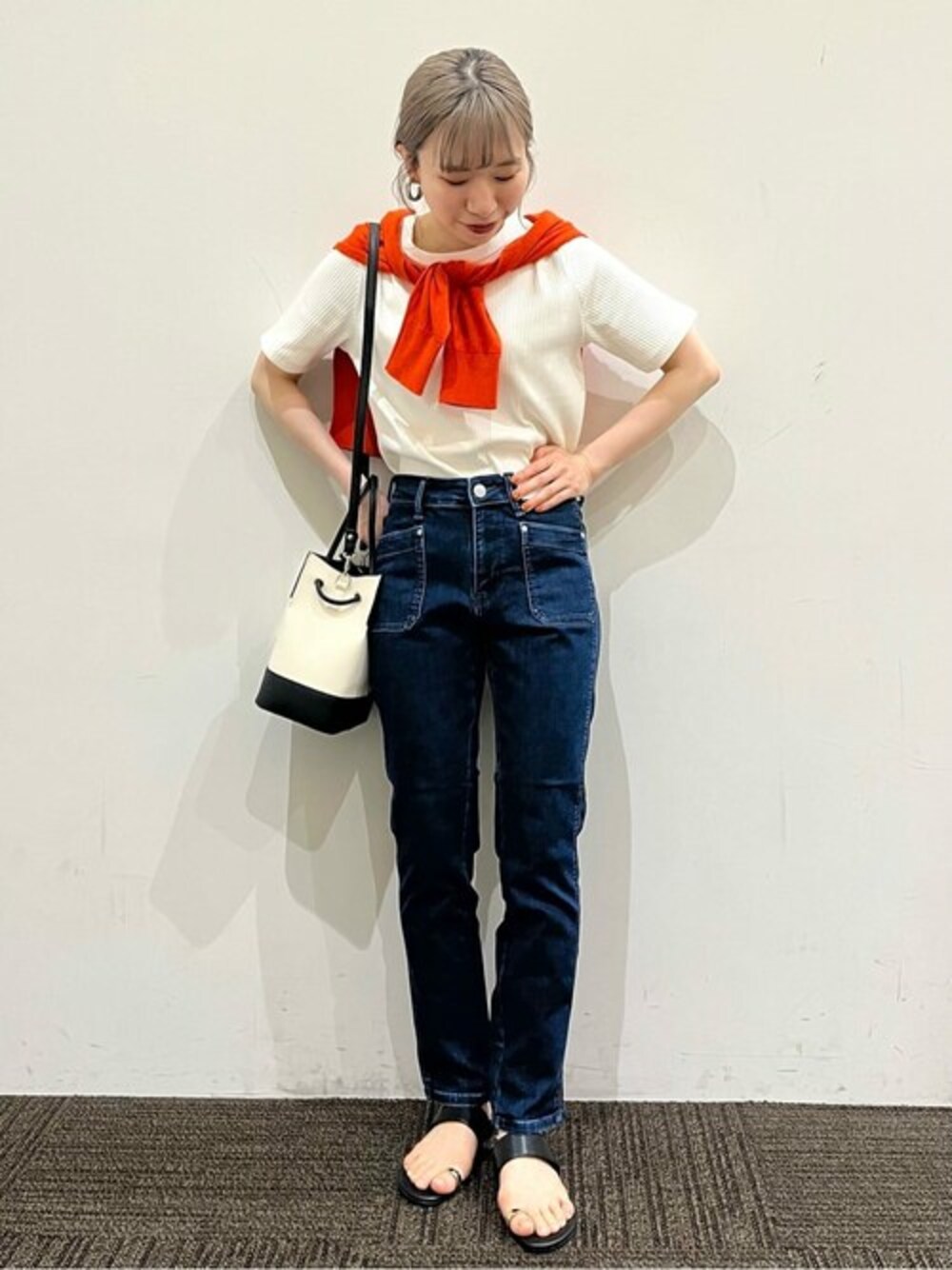 ブルー系のデニムパンツ、ホワイト系のTシャツ/カットソー、オレンジ系のカーディガン/ボレロを着用したレディースの夏コーディネートの1枚目の写真