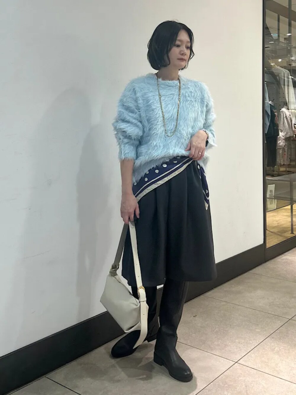 ブルー系のニット/セーター、グレー系のその他パンツ、ブラック系のブーツを着用したレディースの冬コーディネートの1枚目の写真