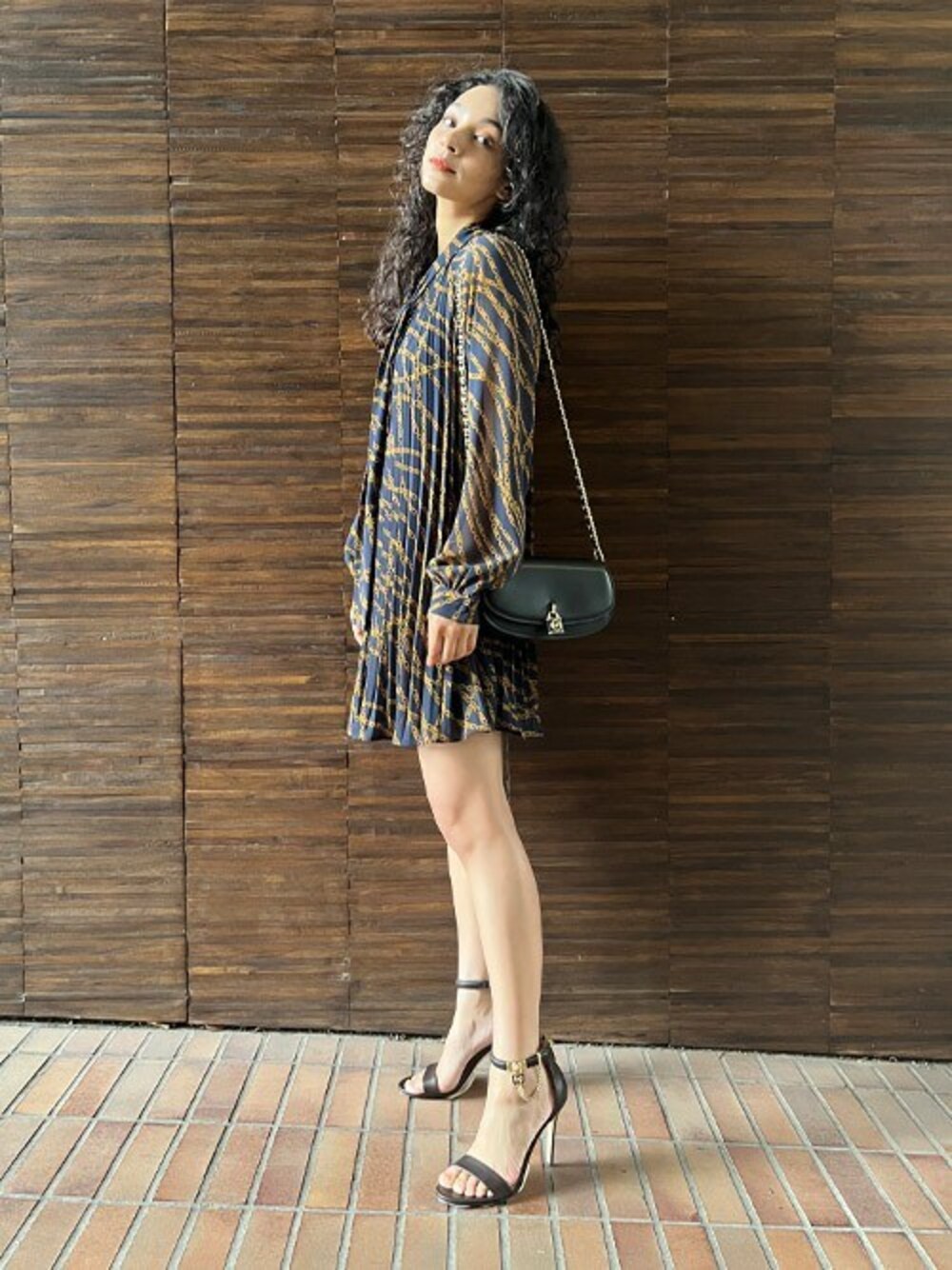 「ショルダーバッグ、マイケルコース、ワンピーススタイル、ミニワンピ、MICHAEL KORS、ミニドレス、チェーン柄、プリーツワンピース」｜「MICHAEL KORSのバイアス エンパイア プリーツ ミニドレス（ワンピース、オレンジ系）」を使った、MICHAEL KORS OFFICIALさん（レディース・166cm）の秋コーディネートの1枚目の写真