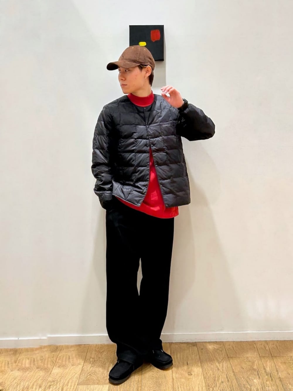 ブラック系のチノパンツ、ブラック系のダウンジャケット/コート、レッド系のTシャツ/カットソーを着用したメンズの冬コーディネートの1枚目の写真