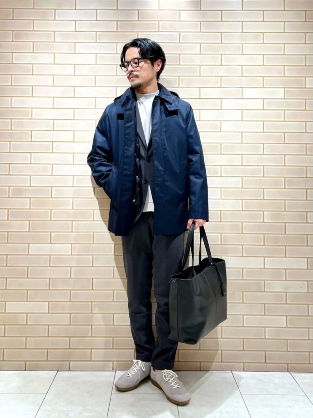 ブラック系のトートバッグ、グレー系のTシャツ/カットソー、ベージュ系のスニーカーを着用したメンズの冬コーディネートの1枚目の写真