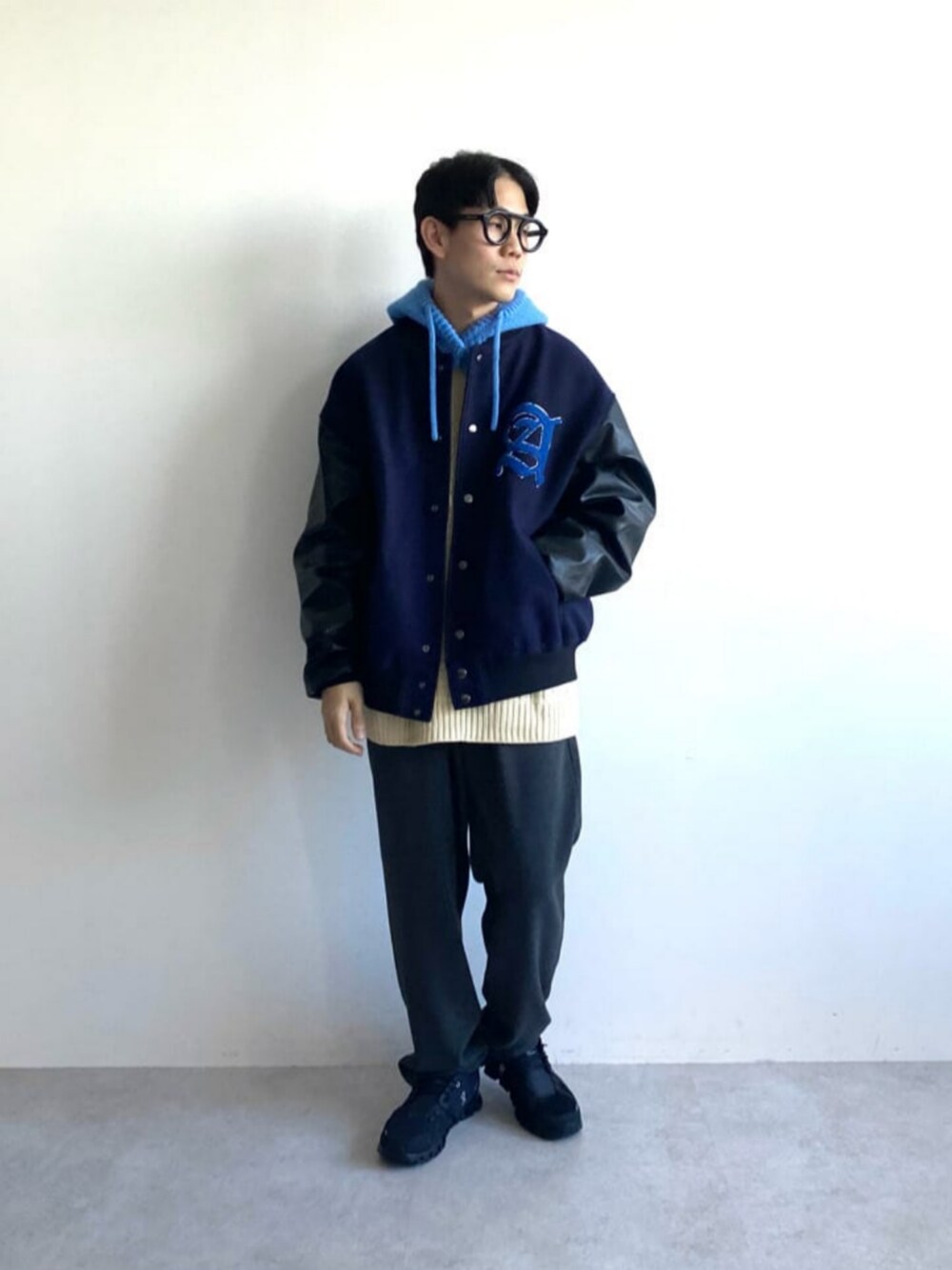 ブルー系のスタジャン、ホワイト系のニット/セーター、グレー系のその他パンツを着用したメンズの秋コーディネートの1枚目の写真