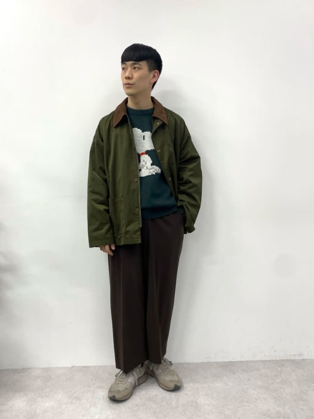 ブラウン系のスニーカー、グリーン系のミリタリージャケット、グリーン系のニット/セーターを着用したメンズの秋コーディネートの1枚目の写真