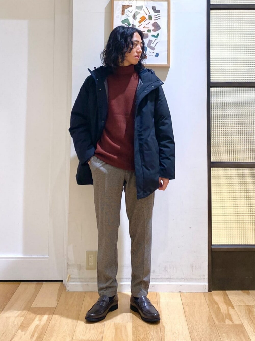 ブラック系のダウンジャケット/コート、レッド系のニット/セーター、ブラウン系のその他パンツを着用したメンズの冬コーディネートの1枚目の写真