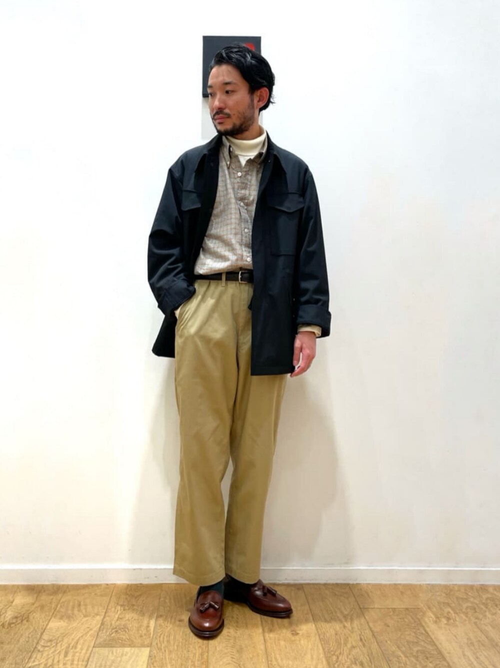 ブラック系のその他アウター、ベージュ系のシャツ/ブラウス、ベージュ系のチノパンツを着用したメンズの冬コーディネートの1枚目の写真