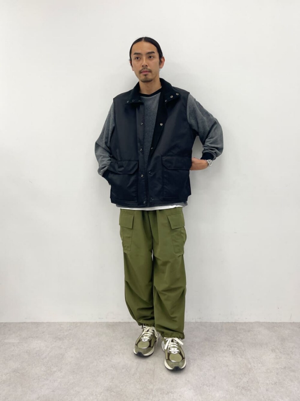 ブラック系のベスト、ブラック系のTシャツ/カットソー、グリーン系のカーゴパンツを着用したメンズの秋コーディネートの1枚目の写真