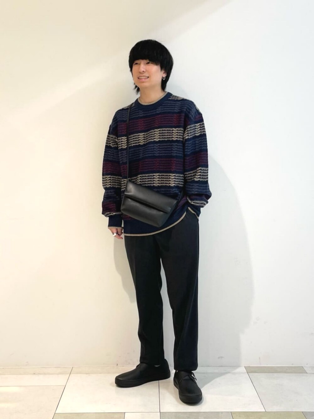 ブラック系のスニーカー、ブルー系のその他パンツ、ブルー系のニット/セーターを着用したメンズの冬コーディネートの1枚目の写真