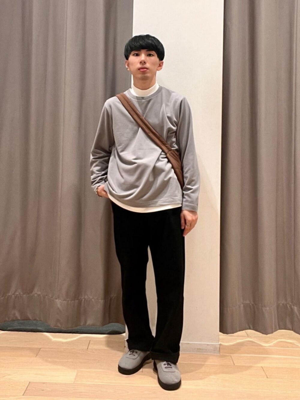 グレー系のTシャツ/カットソー、ブラック系のデニムパンツ、ブラウン系のショルダーバッグを着用したメンズの秋コーディネートの1枚目の写真