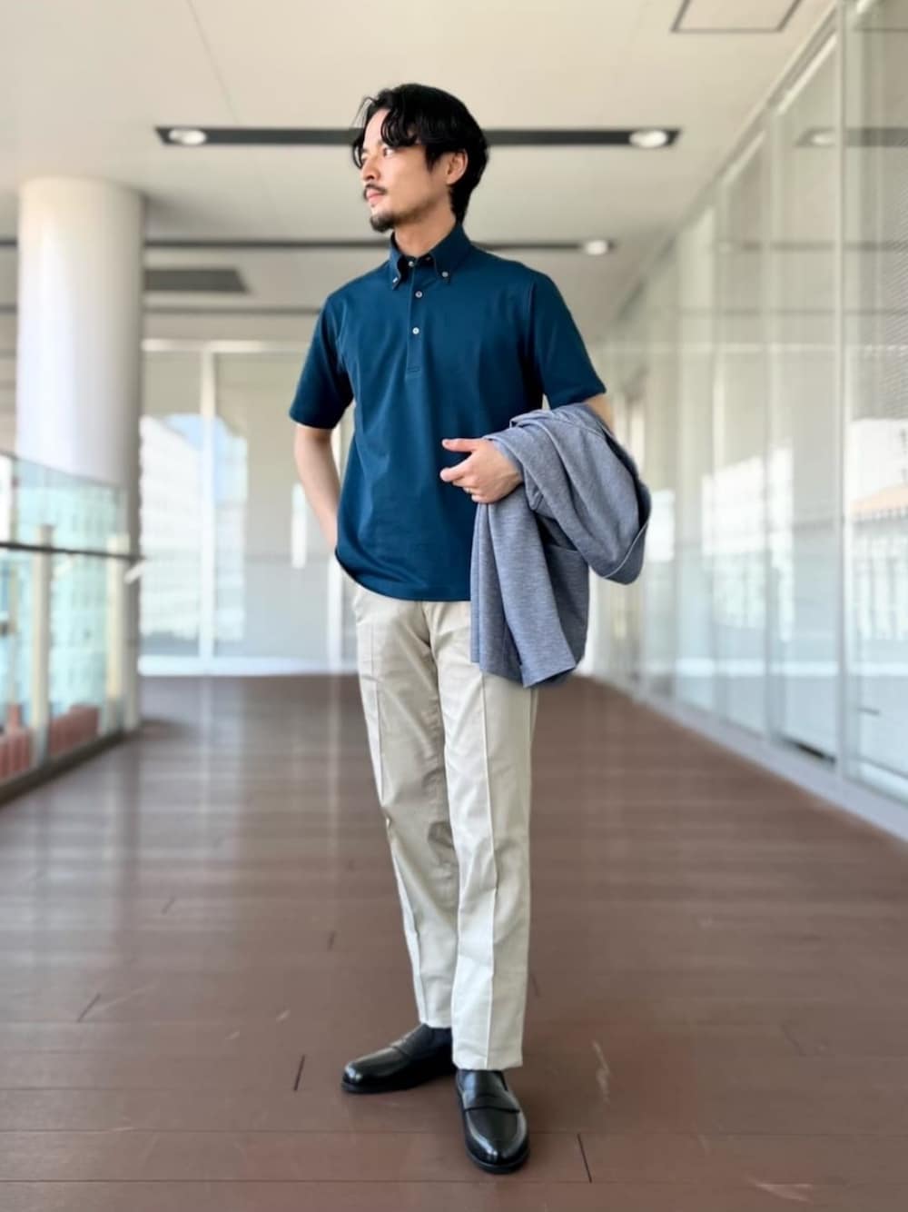ベージュ系のスラックス、グリーン系のポロシャツ、ブラック系のローファーを着用したメンズの夏コーディネートの1枚目の写真