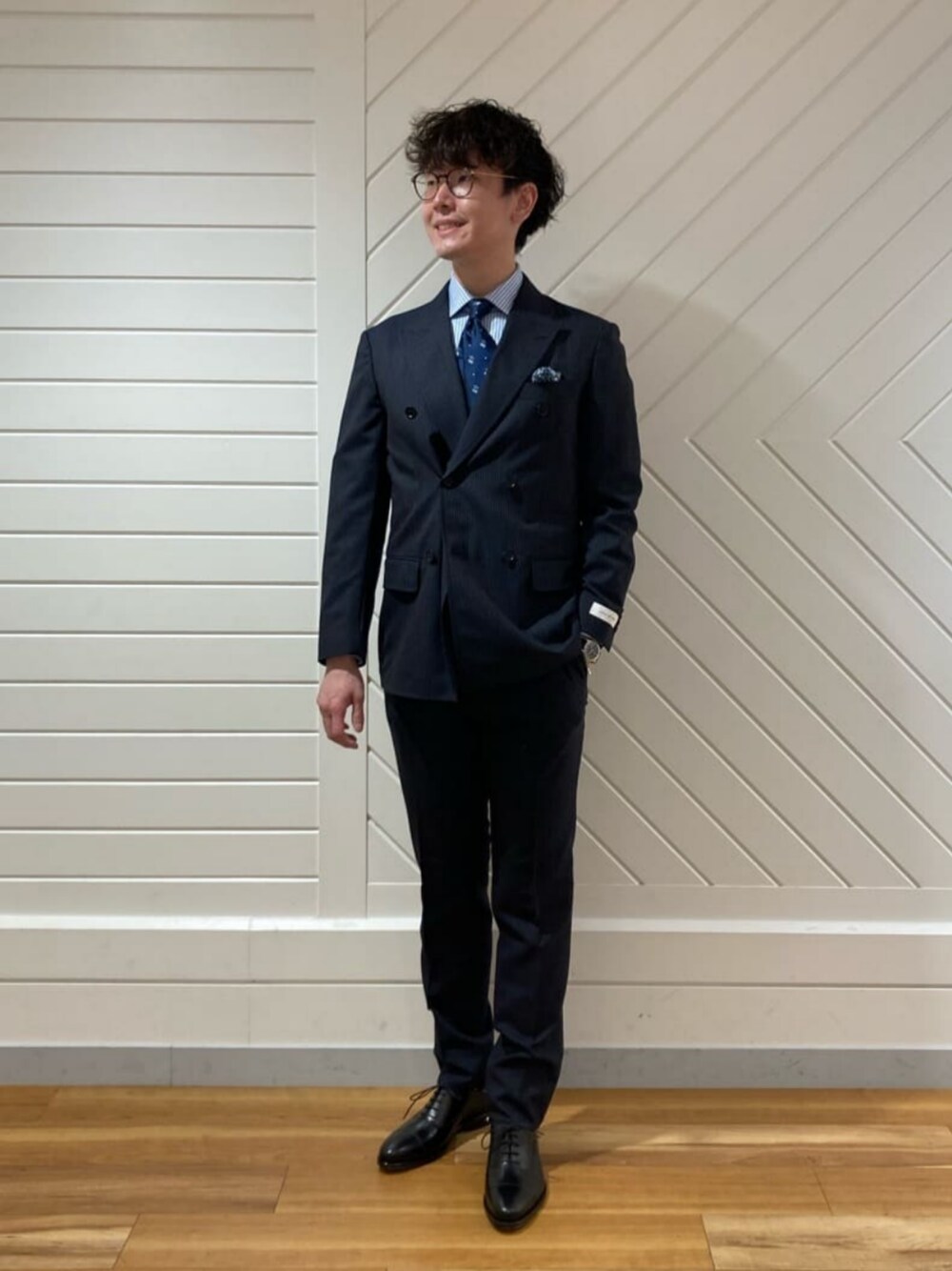 ブルー系のスーツジャケット、ブルー系のスーツパンツ、ブルー系のネクタイを着用したメンズの春コーディネートの1枚目の写真