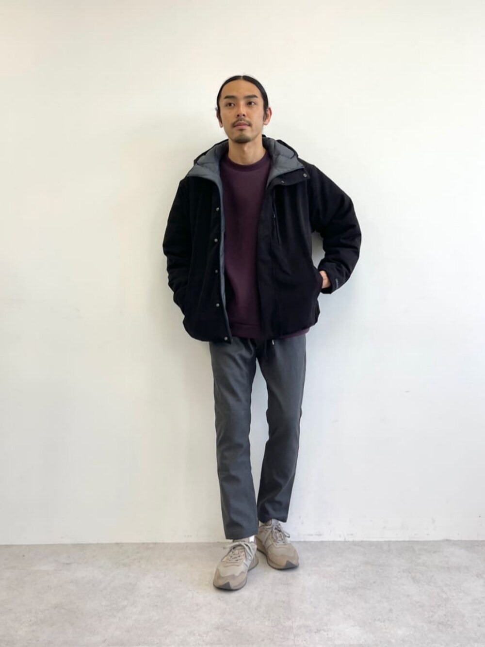 ブラック系のダウンジャケット/コート、ブラウン系のスニーカー、レッド系のスウェットを着用したメンズの秋コーディネートの1枚目の写真