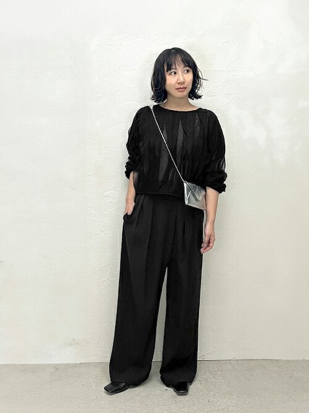 「オールブラック、きれいめコーディネート、ワイドパンツ、春コーデ、フリルトップス、黒コーデ、シルバーバッグ、styledeli、スタイルデリ、シアートップス」｜「STYLE DELIのシアーフリルニットソートップス（その他トップス、ブラック系）」を使った、STYELEDELIさん（レディース・156cm）の春コーディネートの1枚目の写真
