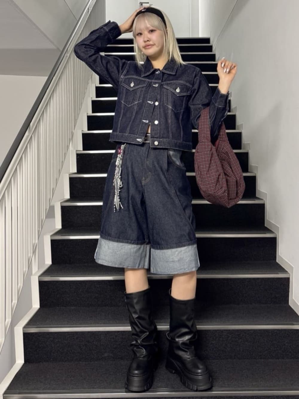 ブラック系のブーツ、ブルー系のデニムジャケット、ブルー系のデニムパンツを着用したレディースの春コーディネートの1枚目の写真