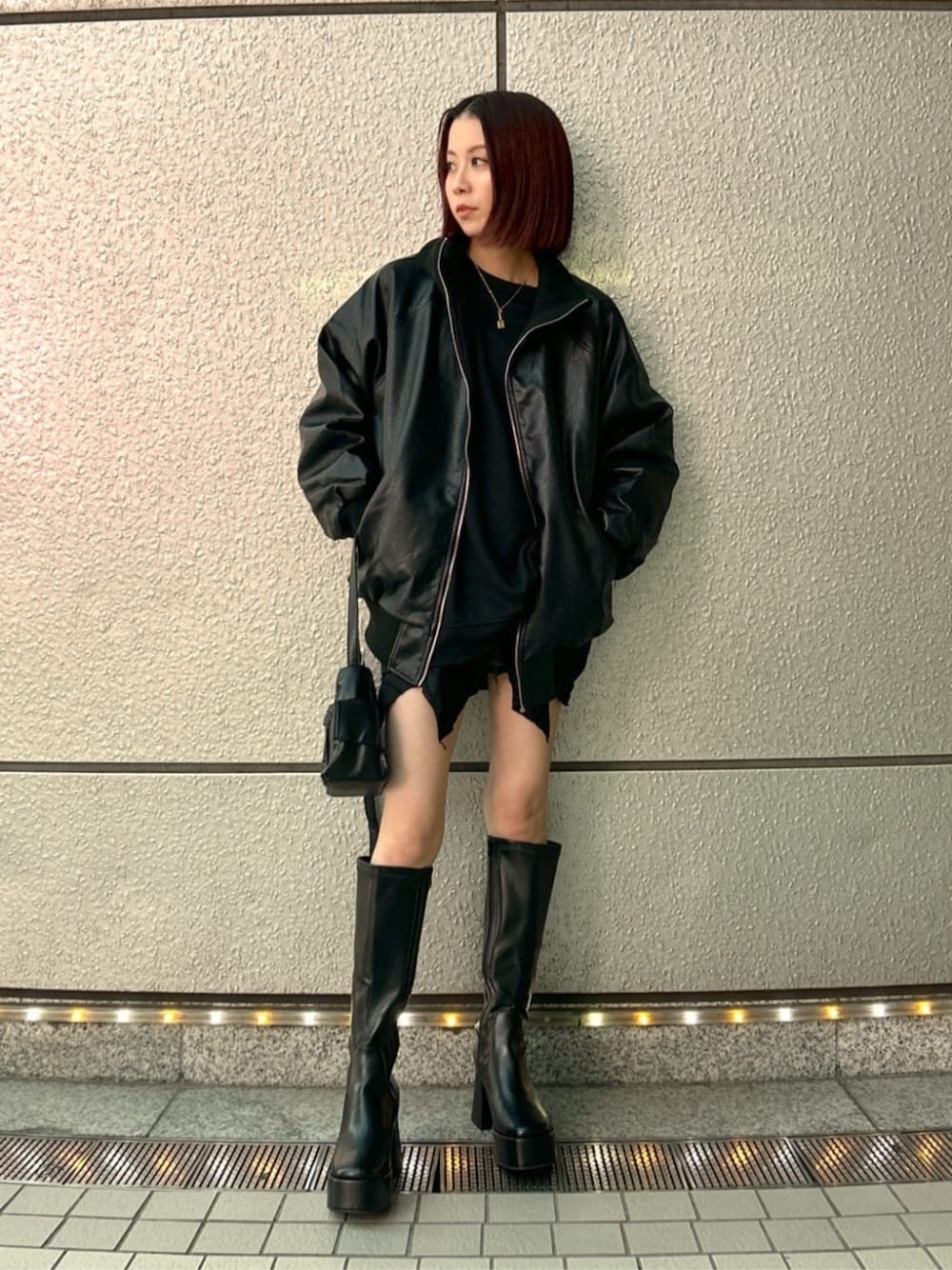 ブラック系のショルダーバッグ、ブラック系のブーツ、ブラック系のスカートを着用したレディースの秋コーディネートの1枚目の写真