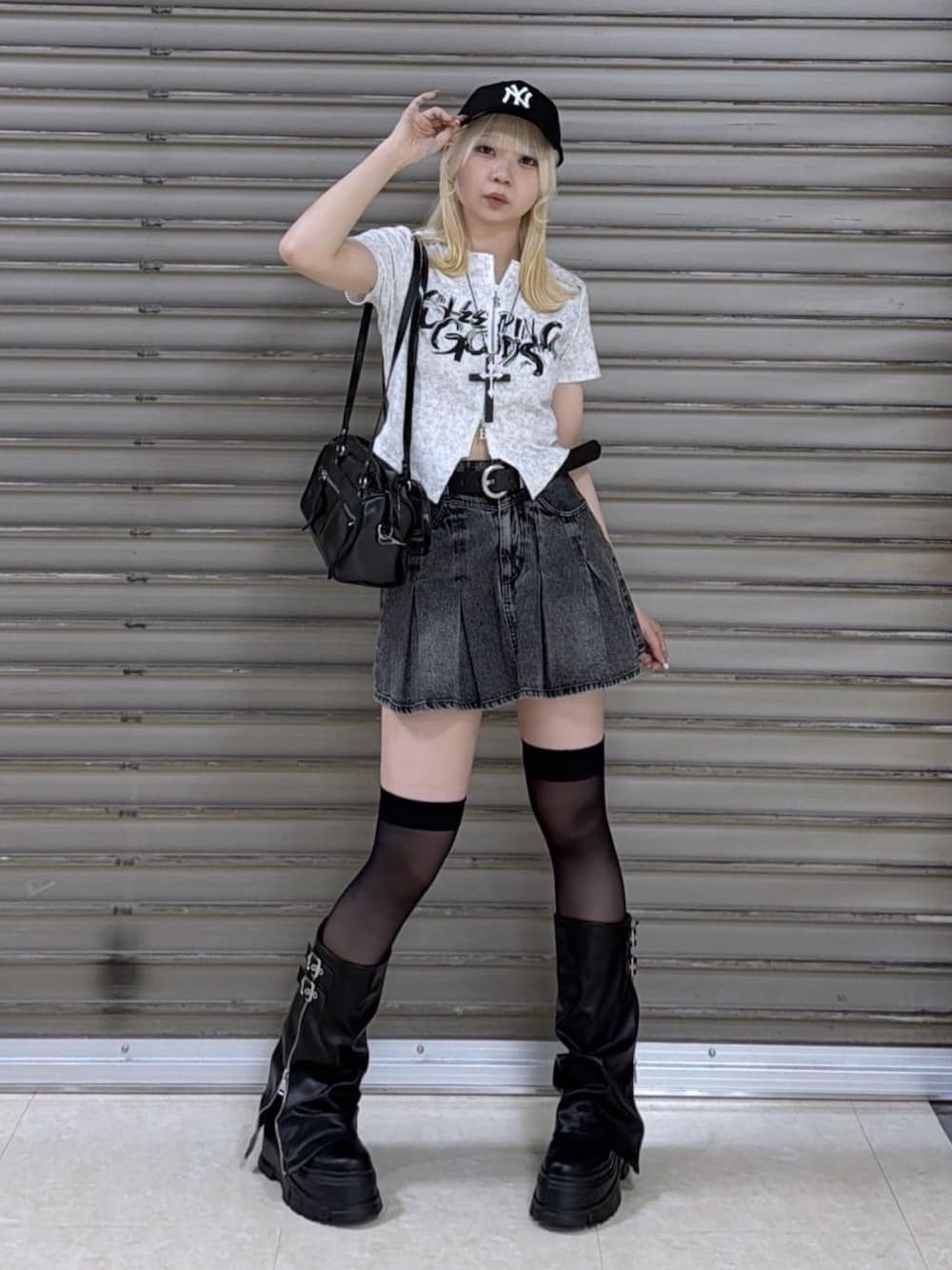 ホワイト系のTシャツ/カットソー、ブラック系のデニムスカート、ブラック系のブーツを着用したレディースの春コーディネートの1枚目の写真