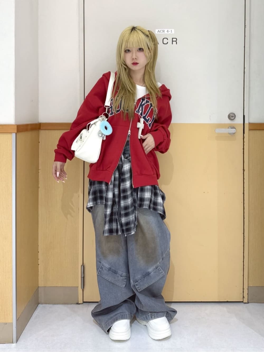 ホワイト系のスニーカー、レッド系のパーカー、ブルー系のデニムパンツを着用したレディースの春コーディネートの1枚目の写真