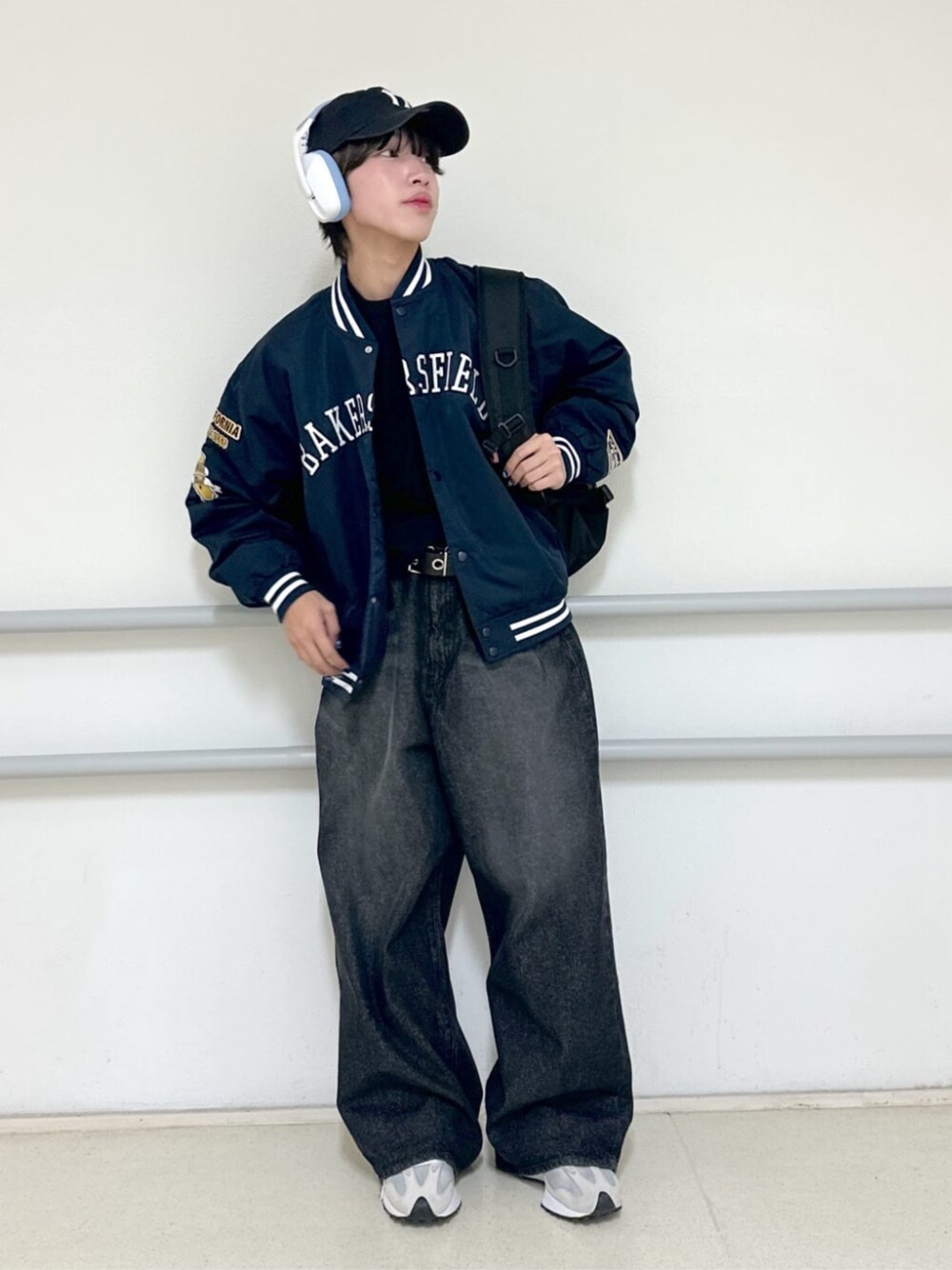 ブラック系のデニムパンツ、ブルー系のスタジャン、その他のバックパック/リュックを着用したメンズの秋コーディネートの1枚目の写真