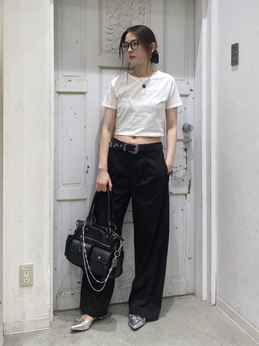 シルバー系のパンプス、ブラック系のショルダーバッグ、ホワイト系のTシャツ/カットソーを着用したレディースの夏コーディネートの1枚目の写真