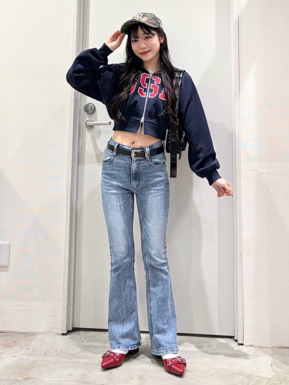 ブルー系のパーカー、ブルー系のデニムパンツ、レッド系のパンプスを着用したレディースの春コーディネートの1枚目の写真