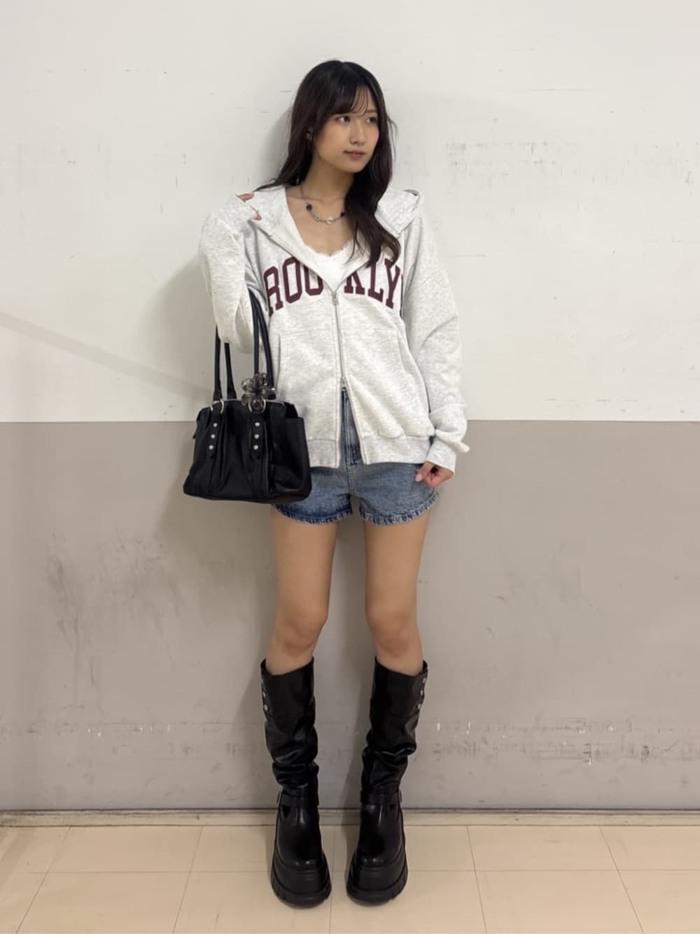 ブラック系のハンドバッグ、ブルー系のその他パンツ、グレー系のパーカーを着用したレディースの秋コーディネートの1枚目の写真