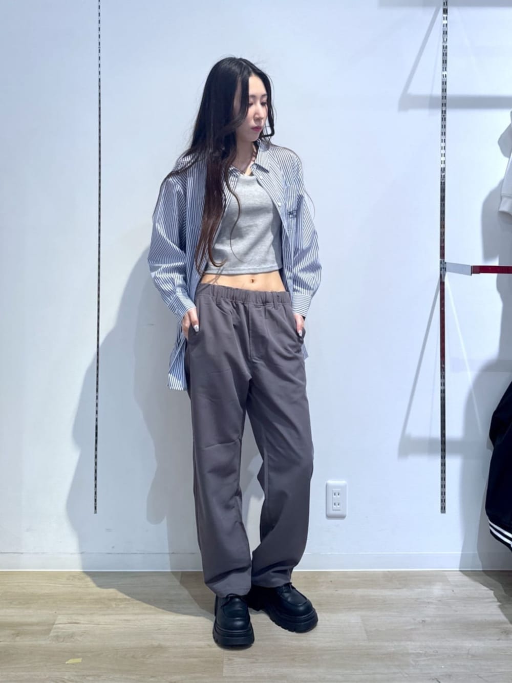 ブルー系のシャツ/ブラウス、グレー系のタンクトップ、グレー系のスラックスを着用したレディースの春コーディネートの1枚目の写真