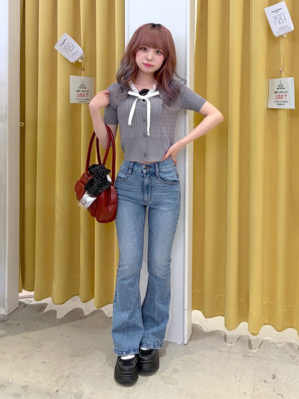 レッド系のボストンバッグ、ブルー系のデニムパンツ、グレー系のTシャツ/カットソーを着用したレディースの夏コーディネートの1枚目の写真