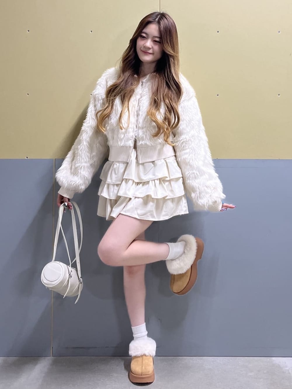 ホワイト系のブルゾン、ホワイト系のスカート、イエロー系のブーツを着用したレディースの秋コーディネートの1枚目の写真