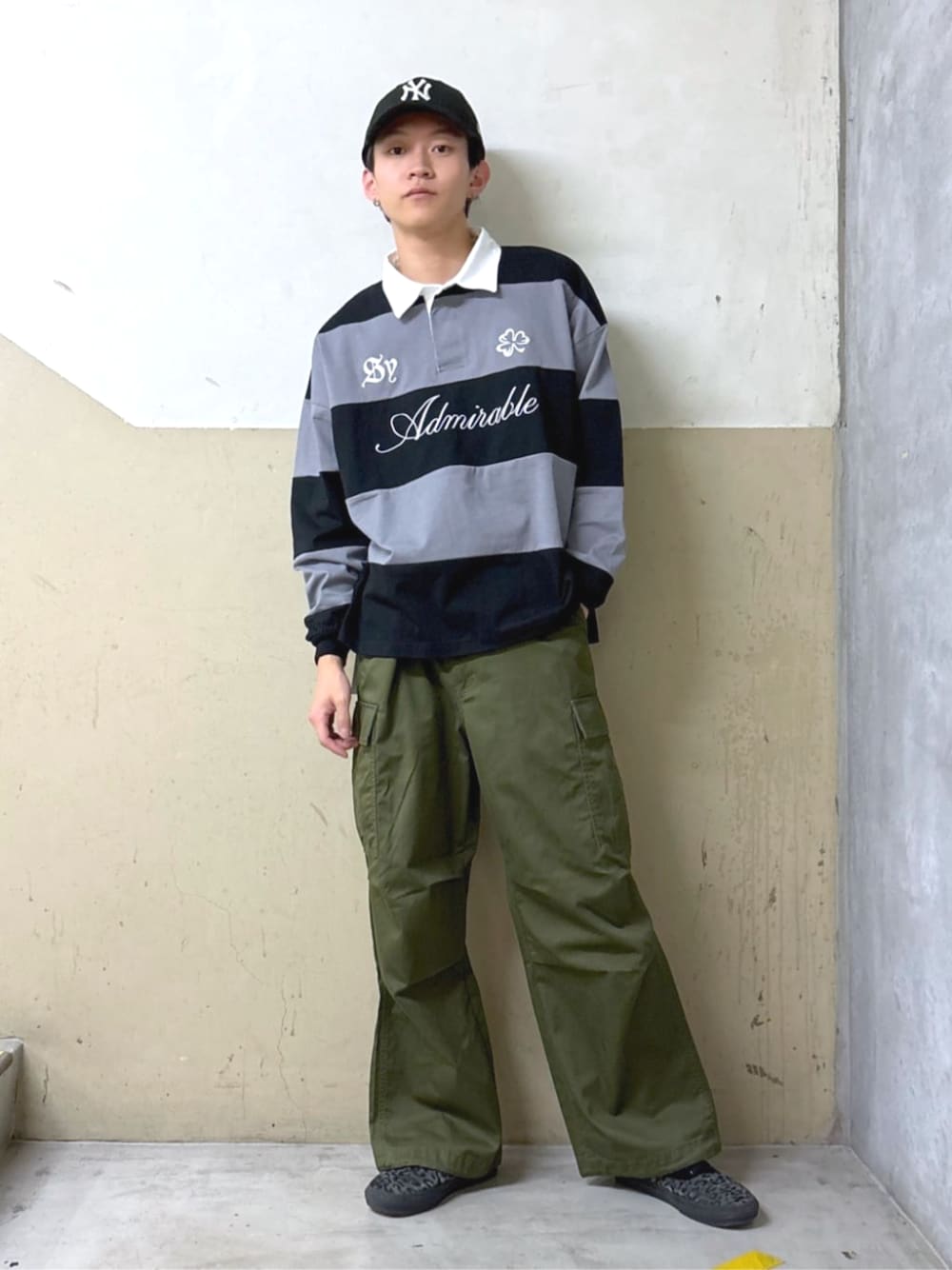 グリーン系のカーゴパンツ、ブラック系のTシャツ/カットソーを着用したメンズの春コーディネートの1枚目の写真