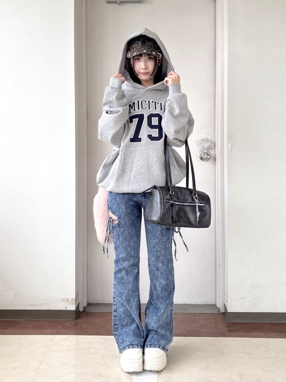 ブルー系のデニムパンツ、グレー系のパーカー、ホワイト系のスニーカーを着用したレディースの冬コーディネートの1枚目の写真