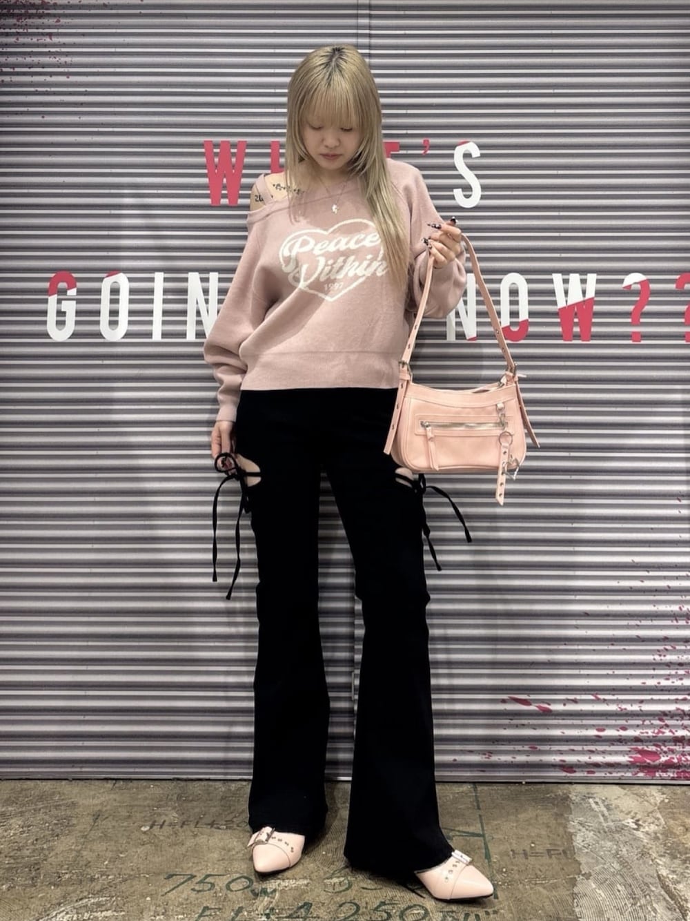 ブラック系のデニムパンツ、ピンク系のニット/セーター、ピンク系のショルダーバッグを着用したレディースの冬コーディネートの1枚目の写真