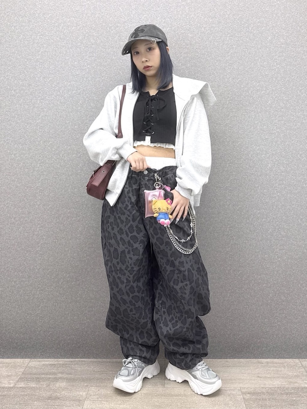 グレー系のパーカー、その他のデニムパンツ、シルバー系のスニーカーを着用したレディースの春コーディネートの1枚目の写真