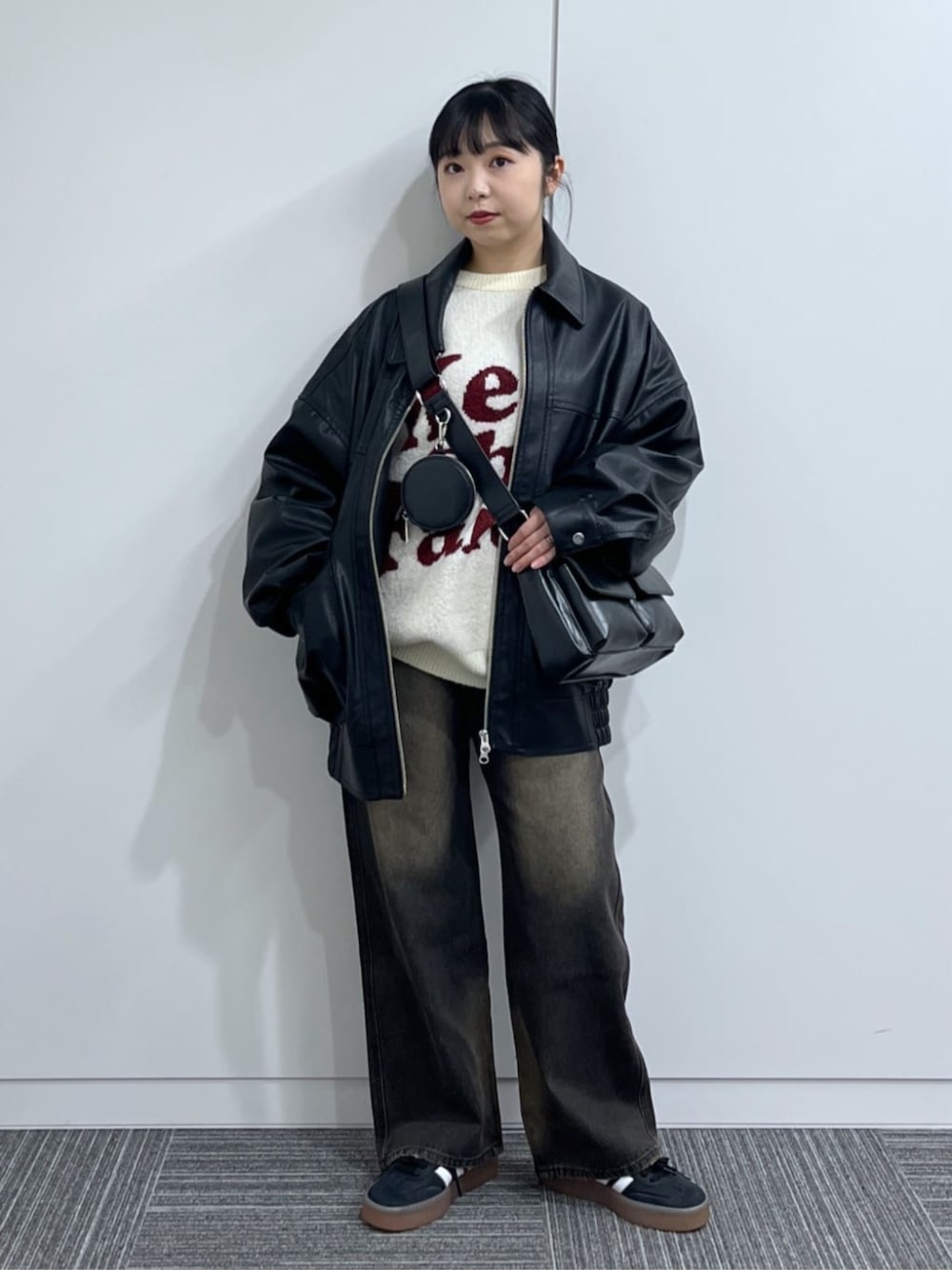 ブラック系のショルダーバッグ、ブラック系のデニムパンツ、ホワイト系のニット/セーターを着用したレディースの冬コーディネートの1枚目の写真