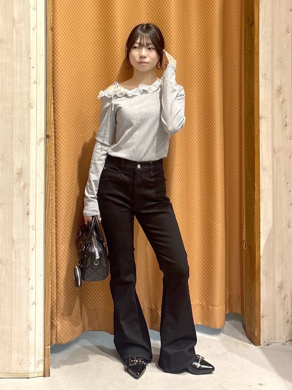 ブラック系のデニムパンツ、グレー系のTシャツ/カットソー、ブラック系のパンプスを着用したレディースの冬コーディネートの1枚目の写真