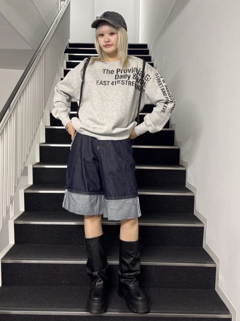 ブルー系のデニムパンツ、その他のスウェット、ブラック系のブーツを着用したレディースの春コーディネートの1枚目の写真