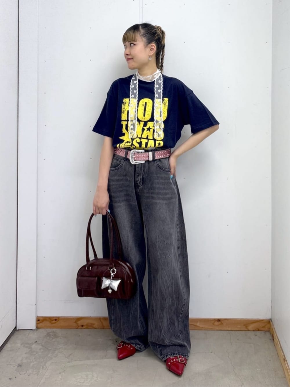 ブラウン系のボストンバッグ、レッド系のパンプス、ブラック系のデニムパンツを着用したレディースの夏コーディネートの1枚目の写真