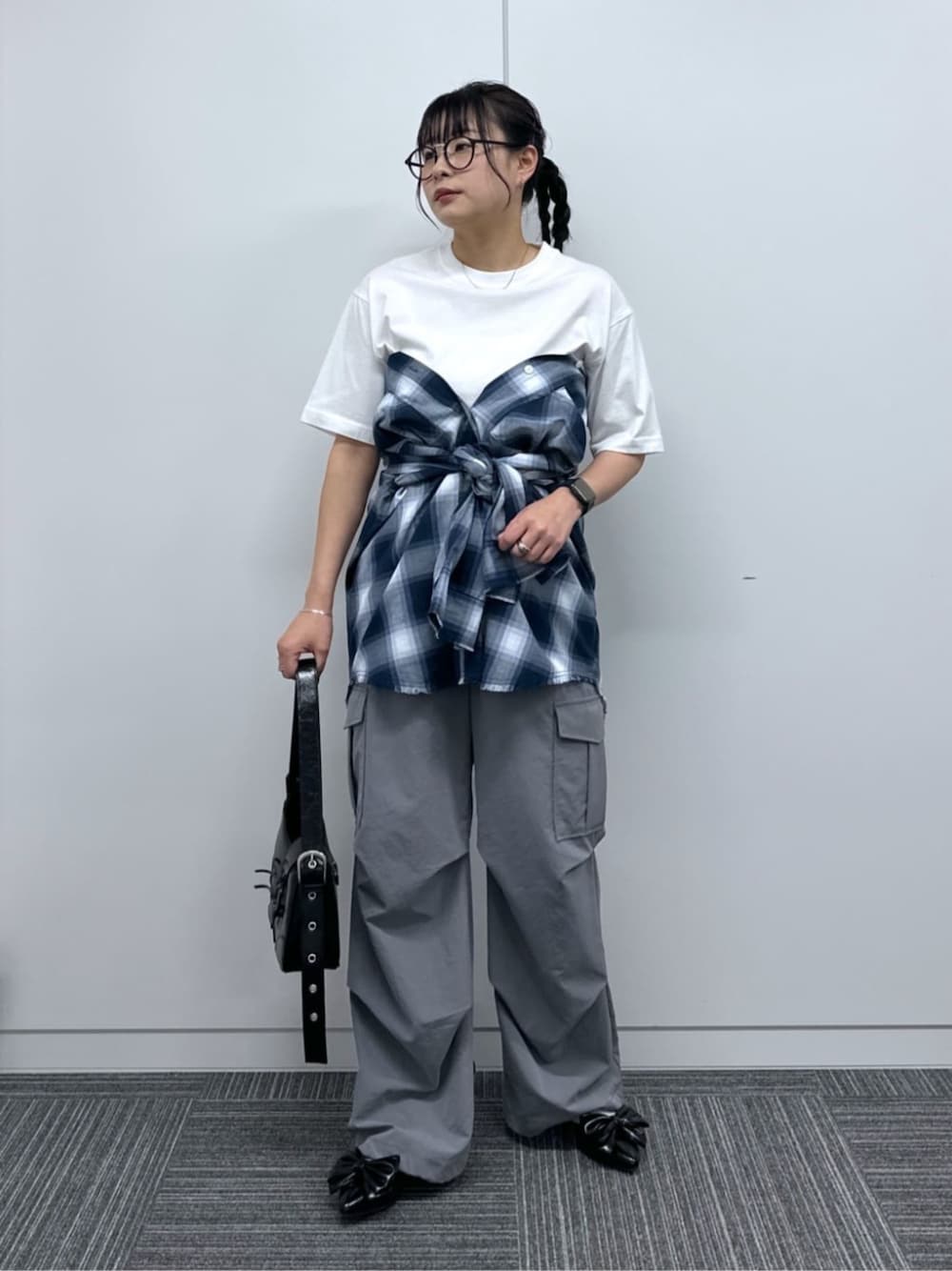 グレー系のカーゴパンツ、ブラック系のハンドバッグ、ブラック系のパンプスを着用したレディースの春コーディネートの1枚目の写真