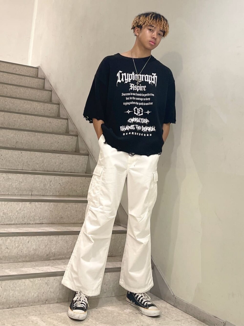 ホワイト系のカーゴパンツ、その他のバックパック/リュック、ブラック系のニット/セーターを着用したメンズの春コーディネートの1枚目の写真