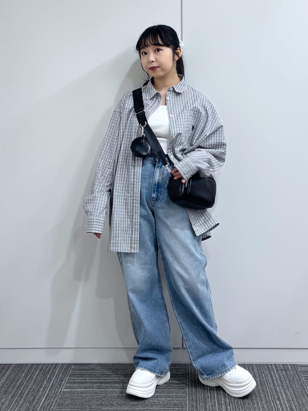 ブラック系のシャツ/ブラウス、ブルー系のデニムパンツ、ホワイト系のスニーカーを着用したレディースの冬コーディネートの1枚目の写真