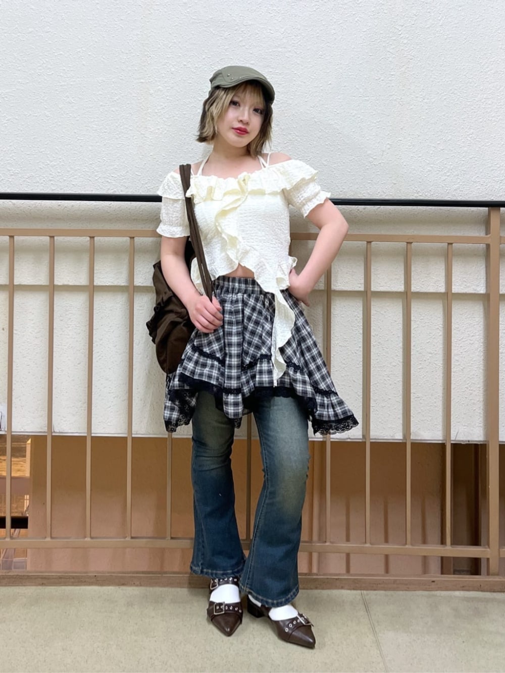 ホワイト系のTシャツ/カットソー、ブラック系のスカート、ブルー系のデニムパンツを着用したレディースの春コーディネートの1枚目の写真