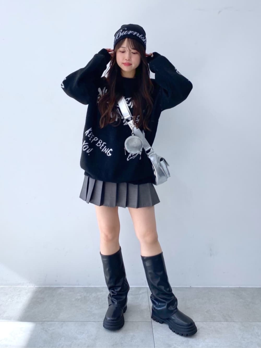 シルバー系のショルダーバッグ、ブラック系のブーツ、ブラック系のニット/セーターを着用したレディースの秋コーディネートの1枚目の写真