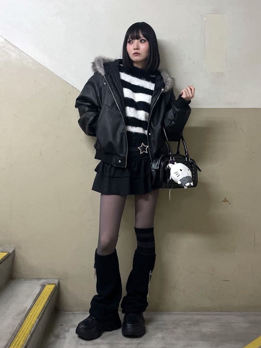 ブラック系のブルゾン、ホワイト系のニット/セーター、ブラック系のスニーカーを着用したレディースの春コーディネートの1枚目の写真