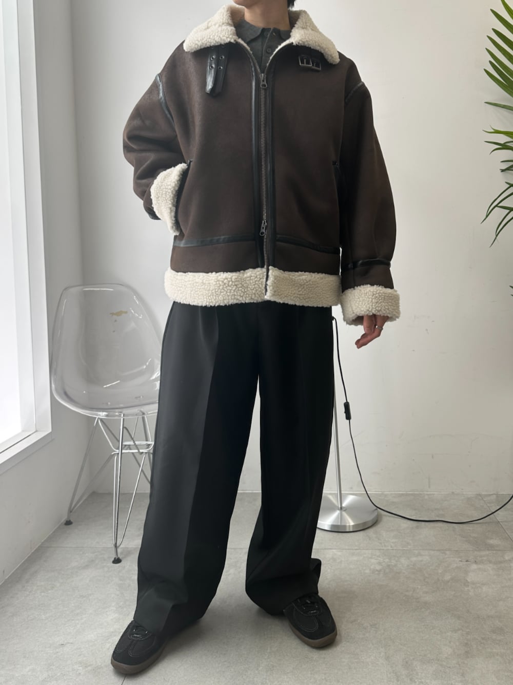 ブラック系のスラックス、ブラウン系のムートンコートを着用したメンズの秋コーディネートの1枚目の写真