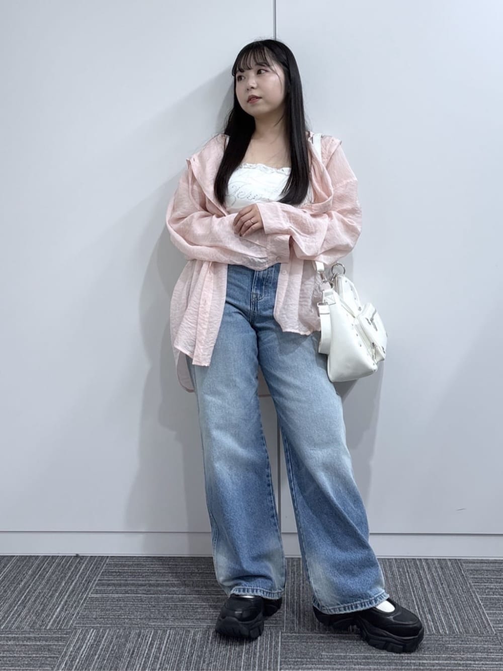 ブルー系のデニムパンツ、ピンク系のシャツ/ブラウス、ホワイト系のショルダーバッグを着用したレディースの春コーディネートの1枚目の写真