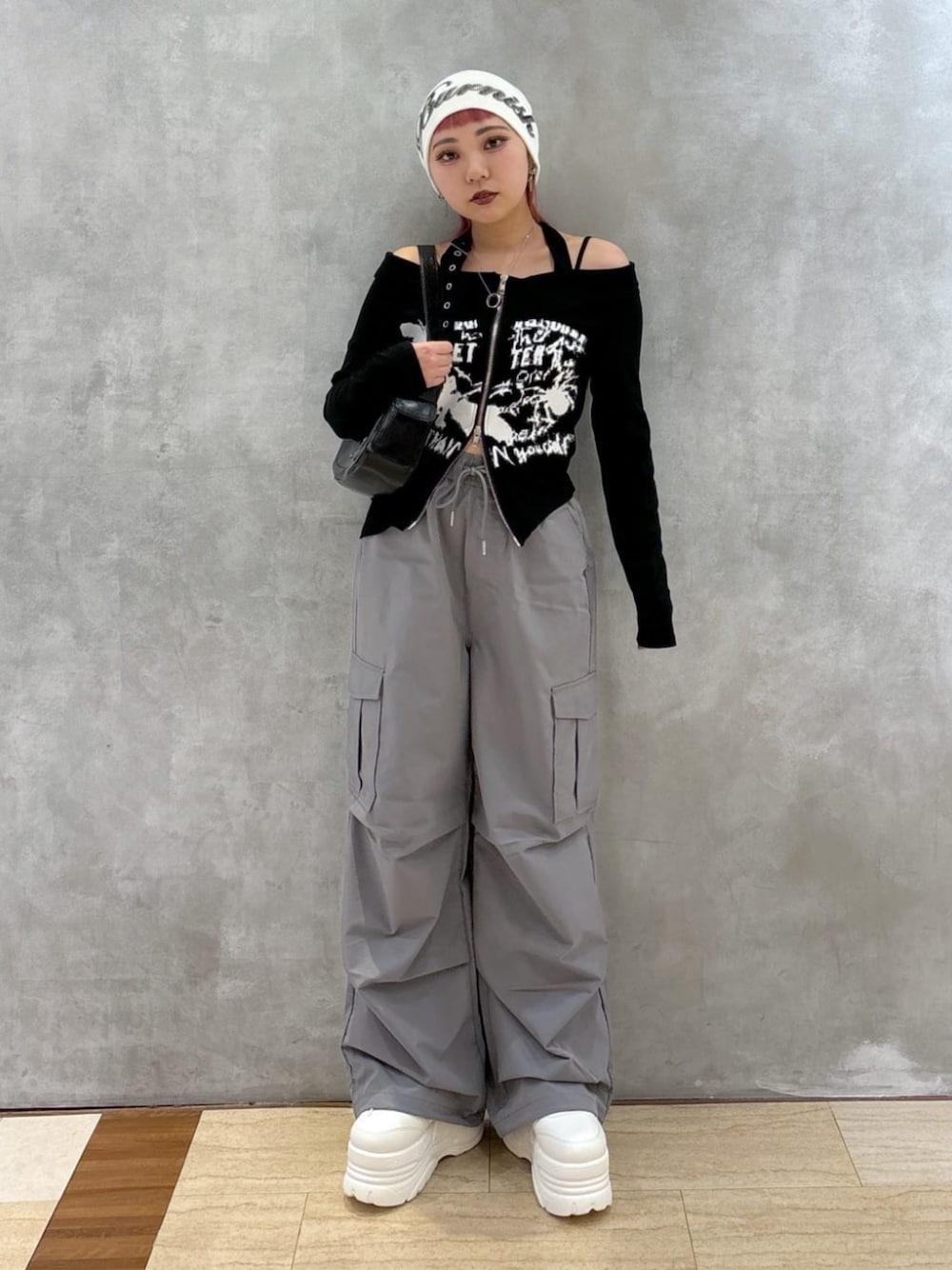 グレー系のカーゴパンツ、ブラック系のショルダーバッグ、ホワイト系のスニーカーを着用したレディースの冬コーディネートの1枚目の写真