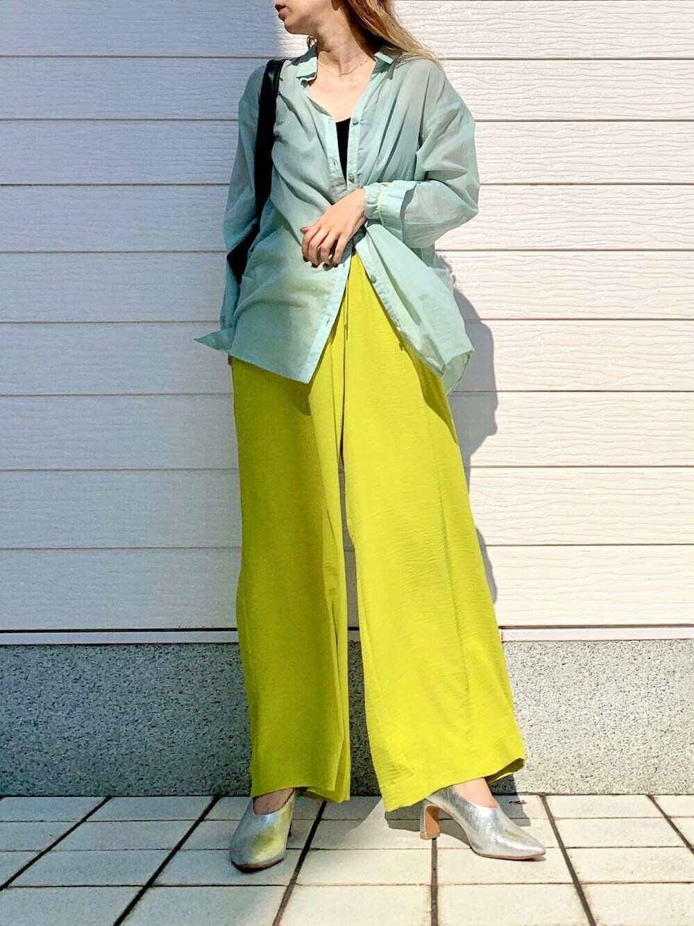 グリーン系のシャツ/ブラウス、イエロー系のその他パンツ、ブラック系のトートバッグを着用したレディースの夏コーディネートの1枚目の写真