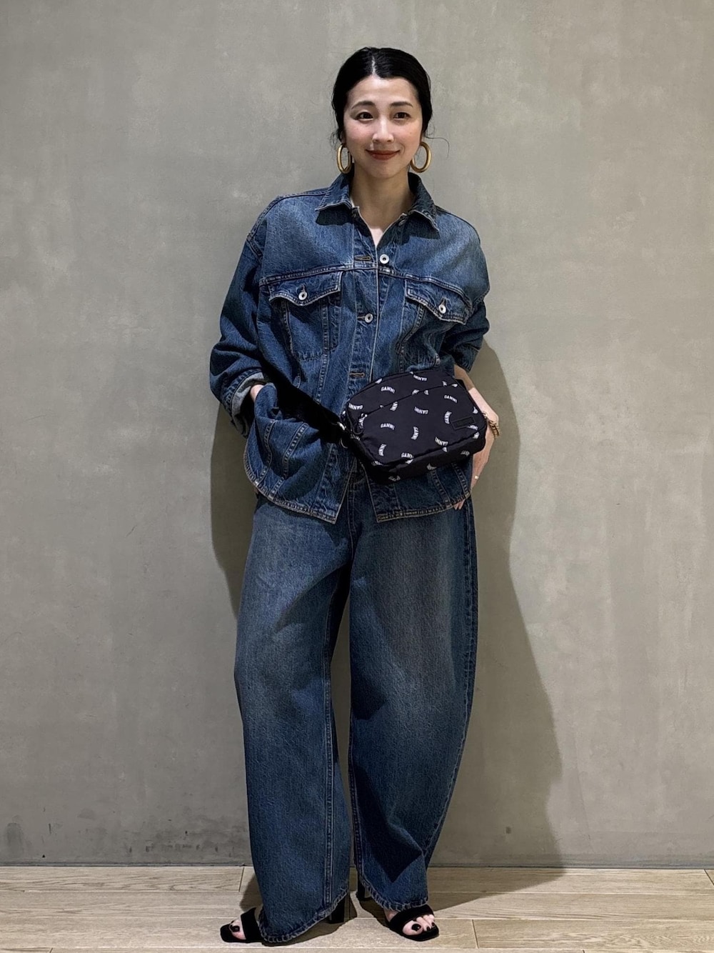 ブルー系のデニムジャケット、ブルー系のデニムパンツ、ブラック系のトートバッグを着用したレディースの春コーディネートの1枚目の写真