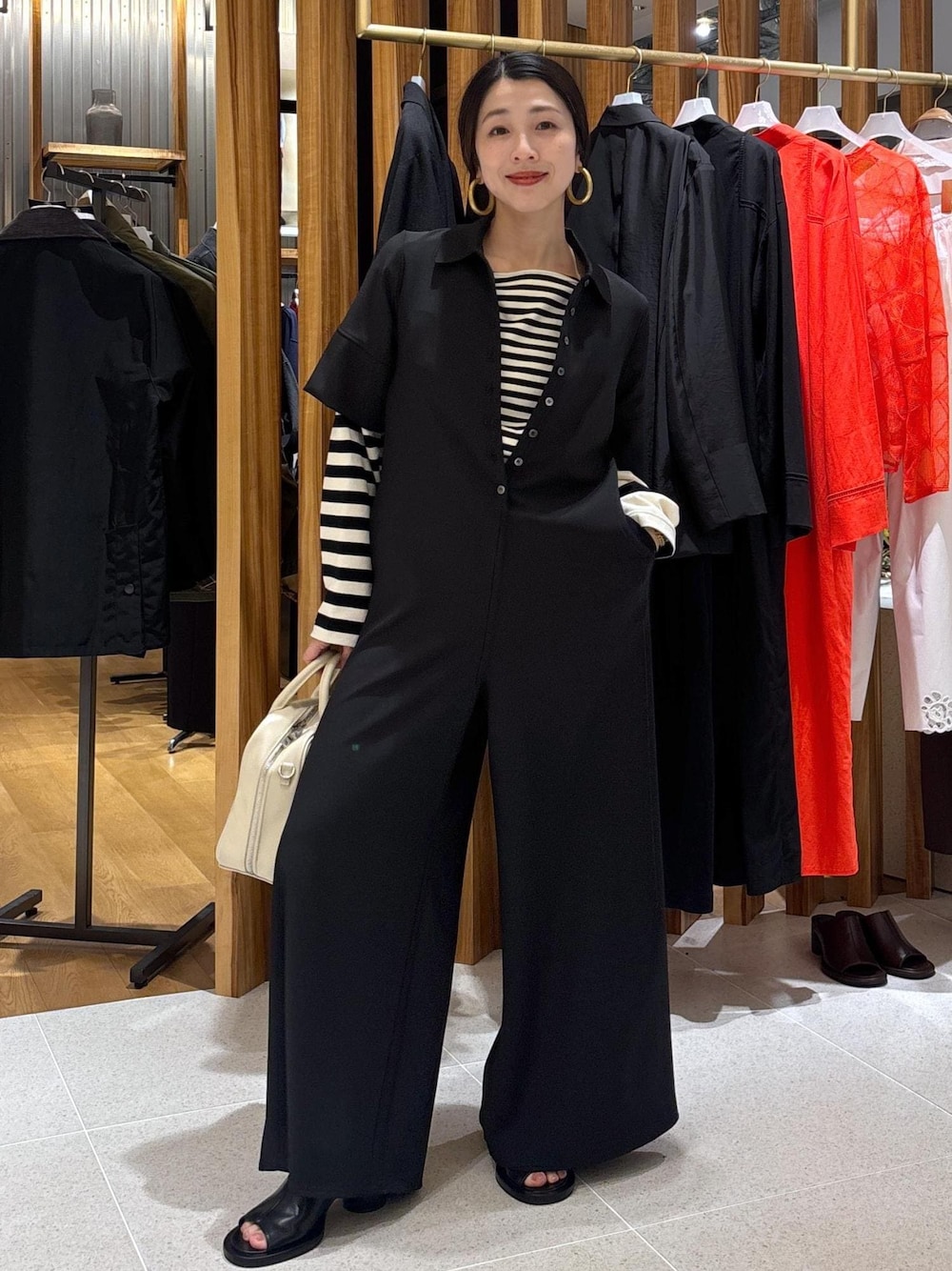 ブラック系のTシャツ/カットソー、ブラック系のつなぎ/オールインワン、ブラック系のサンダルを着用したレディースの春コーディネートの1枚目の写真