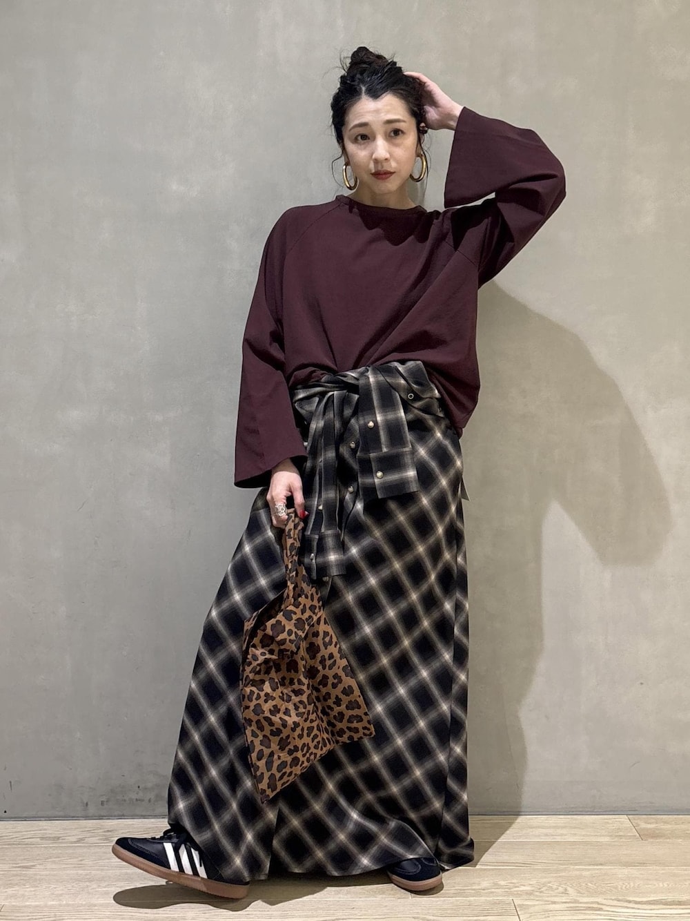 ブラック系のスニーカーを着用したレディースの秋コーディネートの1枚目の写真